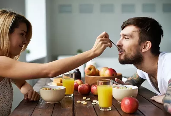 Woman feeds dry fruits to man to increase potency